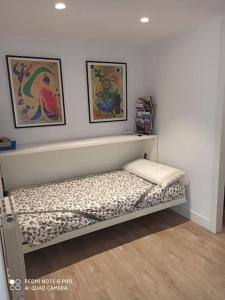 Zimmer mit einem Bett und zwei Gemälden an der Wand in der Unterkunft Acogedor y precioso apartamento + parking privado in San Sebastián