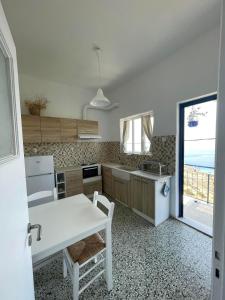 cocina con mesa blanca y vistas al océano en Kardiani Village Home, en Kardhianí