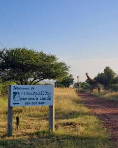 un cartel con dos jirafas caminando en el campo en Tranquillity Day Spa & Lodge, en Baviaanspoort