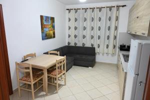 sala de estar con mesa y sofá en Iris apartaments, en Sakës