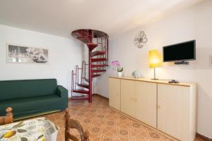 sala de estar con sofá verde y escalera en Casa Verde, en Castellammare del Golfo