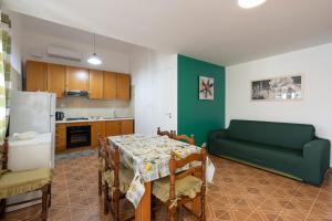 cocina con mesa y sofá en una habitación en Casa Verde, en Castellammare del Golfo