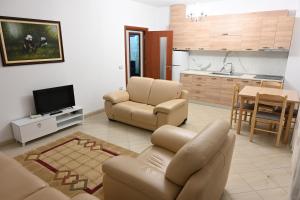 sala de estar con sofá y sillas y cocina en Iris apartaments, en Sakës