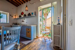 a kitchen with blue cabinets and a table and chairs at Loft il Mare Rio Marina front sea in Rio Marina