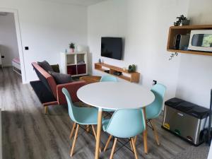 uma sala de estar com uma mesa e cadeiras brancas em Douro Mesio Guest House em Resende