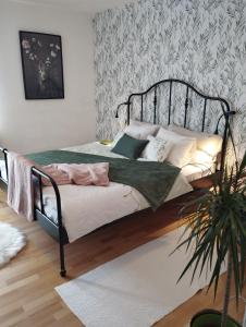 a bedroom with a bed with a black metal frame at Apartmani Gruzdovo in Delnice