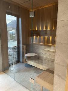 LyngværetにあるLuksushytte med Jacuzzi, Summer&Winter Retreatのバスルーム(ガラス張りのシャワー、トイレ付)