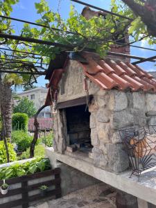un horno de piedra para pizzas en un patio con techo en Lovre en Viskovo
