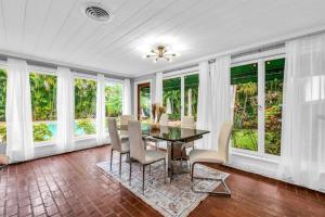 a dining room with a table and chairs and windows at Intracoastal Paradise Walking Distance to Beach! in West Palm Beach