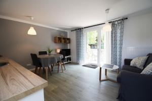 a living room with a table and a couch and a dining room at Am Küstenwald in Ostseebad Koserow