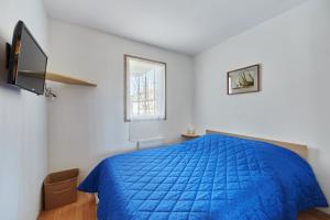 ein Schlafzimmer mit einem blauen Bett und einem Fenster in der Unterkunft Sea Blue - Appt à 1km de la plage in Villers-sur-Mer