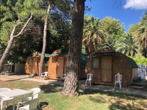 a group of wooden huts with chairs and trees at Pera Garden Airport Hotel in Arnavutköy