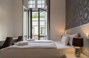 A bed or beds in a room at Hotel Mika Downtown