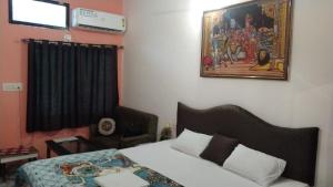 um quarto com uma cama e um quadro na parede em Peaceful Home Stay em Khajurāho