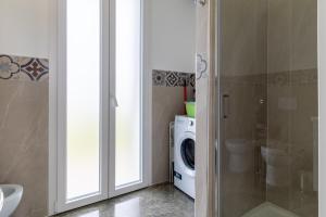 a bathroom with a washing machine and a washer and dryer at Villa melograno in Ispica