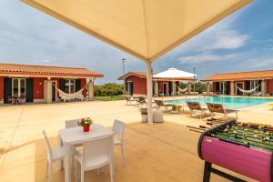 a backyard with a pool and a table and chairs at Villa melograno in Ispica