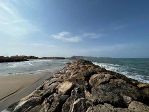 una playa con algunas rocas y el océano en Adosado Estany, en Cullera