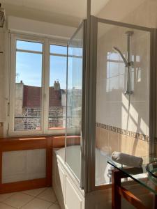 een badkamer met een douche en een raam met uitzicht bij Les Pieds dans l'eau appartement vue mer in Dieppe