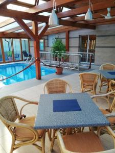 a table and chairs on a patio with a pool at Penzion Bohemia in Lomnice nad Lužnicí