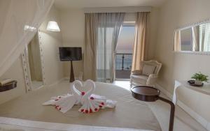 a hotel room with a bed with a heart shaped towel at Main Palace Hotel in Roccalumera