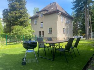 a grill and a table and chairs in front of a house at Centrum No. 1 in Polanica-Zdrój