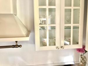un armadietto bianco con porte in vetro in cucina di Apartments Lucy a Milna