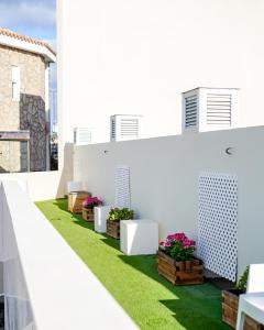 a view of a balcony with green grass and flowers at Cornisa Apartments in Patalavaca