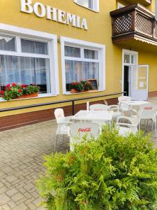 een groep tafels en stoelen voor een gebouw bij Penzion Bohemia in Lomnice nad Lužnicí