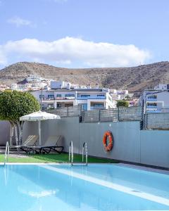 une piscine avec vue sur une ville dans l'établissement Cornisa Apartments, à Patalavaca