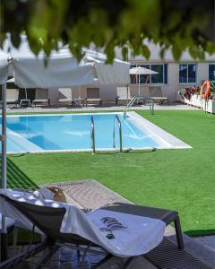 - une piscine avec une chaise en face dans l'établissement Cornisa Apartments, à Patalavaca