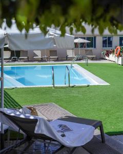 a swimming pool with a chair in front of it at Cornisa Apartments in Patalavaca