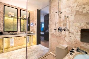 ein Bad mit einer Dusche und einem Waschbecken in der Unterkunft W Guangzhou in Guangzhou