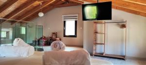 a living room with two chairs and a tv on the wall at Villa ArGia with private pool in Georgioupoli