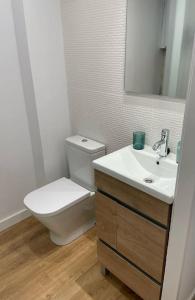 a bathroom with a toilet and a sink and a mirror at Unique apartment in Coruña Old Town in A Coruña