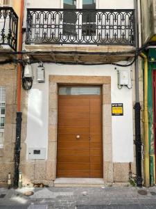 a wooden door on a building with a balcony at Unique apartment in Coruña Old Town in A Coruña