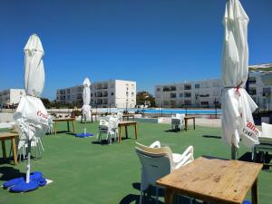 a group of tables and chairs with umbrellas on a patio at Caños de Meca Apartamento frente al mar in Los Caños de Meca