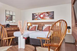 Hotel Gatsby by HappyCulture في شاسيو: غرفة فندقية بسريرين وطاولة وكراسي