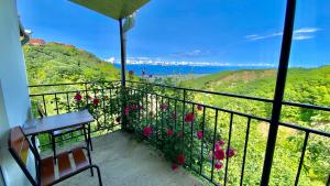 a balcony with a view of the ocean and flowers at Lia's Guest House in Sighnaghi