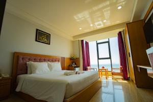 a bedroom with a large bed with a large window at Happy Light Central Nha Trang in Nha Trang