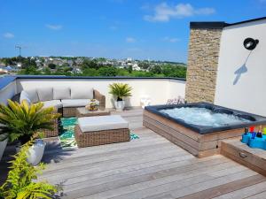 a patio with a hot tub on a roof at La Villa Thelma 5 étoiles, piscine, sauna et jacuzzi in Granville