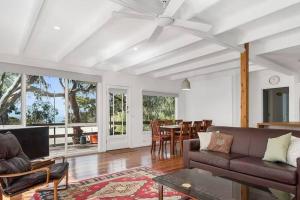 un soggiorno con un divano e un tavolo di Whispering Gums - Ocean Views, Pet Friendly, EV UNIT 7kW for electric cars, Sleeps 7 a Lorne