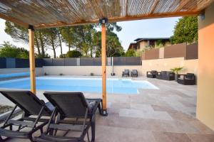 Birac-sur-Trec的住宿－Gîte tout confort entre Marmande et Tonneins，一个带椅子的庭院和一个游泳池
