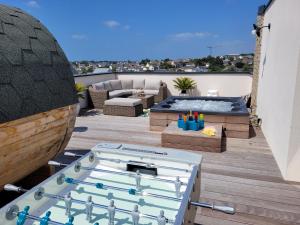 eine Terrasse mit Whirlpool und Whirlpool in der Unterkunft La Villa Thelma 5 étoiles, piscine, sauna et jacuzzi in Granville