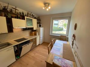 a kitchen with a table and a refrigerator and a window at Virgin'A in Nida