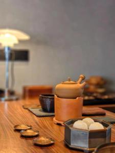 a table with a pot and some coins on it at Jiangnan House Chaozhou in Chaozhou