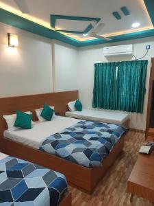 a bedroom with two beds and a window at Hotel Sai Dakshina Inn in Shirdi