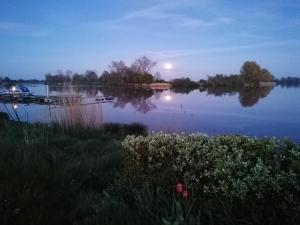einen Blick auf einen See mit dem Mond, der auf dem Wasser reflektiert in der Unterkunft Ferienpark Süderstapel in Süderstapel