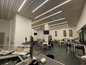 una gran habitación con mesas y sillas y una cafetería en Eurocity Hotel Santander Centro, en Santander