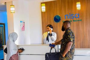 a woman talking on a cell phone next to a nurse at Nisa Wellness Retreat in Abuja +22 photos