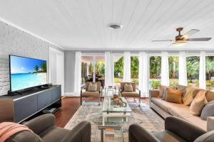 a living room with a couch and a tv at Intracoastal Paradise Walking Distance to Beach! in West Palm Beach